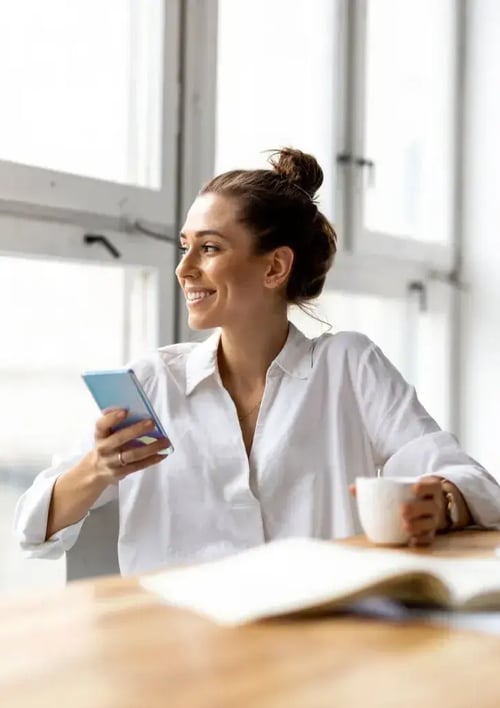 woman sat at desk, looking out the window while working-1